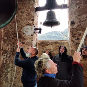 Cinc alumnes de l'Escola de campaners Llorenç Llongarriu són al campanar de Joanetes practicant les tècniques de fer sonar les campanes.
